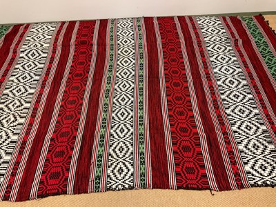 Lot 130 - An African blanket decorated in shades of red,...