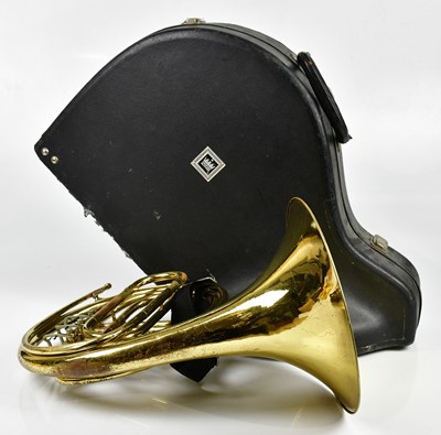 Lot 1165 - CLEVELAND; a brass plated French horn, cased.