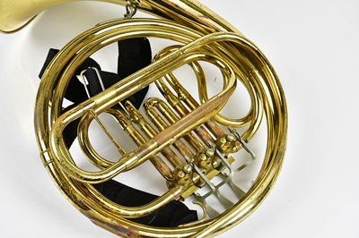 Lot 1165 - CLEVELAND; a brass plated French horn, cased.