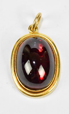 Lot 395 - An 18ct yellow gold garnet cabochon pendant,...