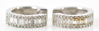 Lot 642 - A pair of 14ct white gold baguette and round...