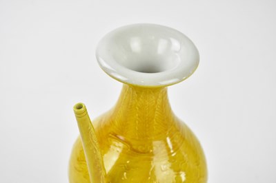 Lot 1063 - A Chinese yellow ground ewer, relief decorated...