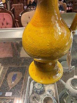 Lot 1063 - A Chinese yellow ground ewer, relief decorated...