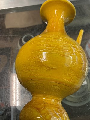 Lot 1063 - A Chinese yellow ground ewer, relief decorated...