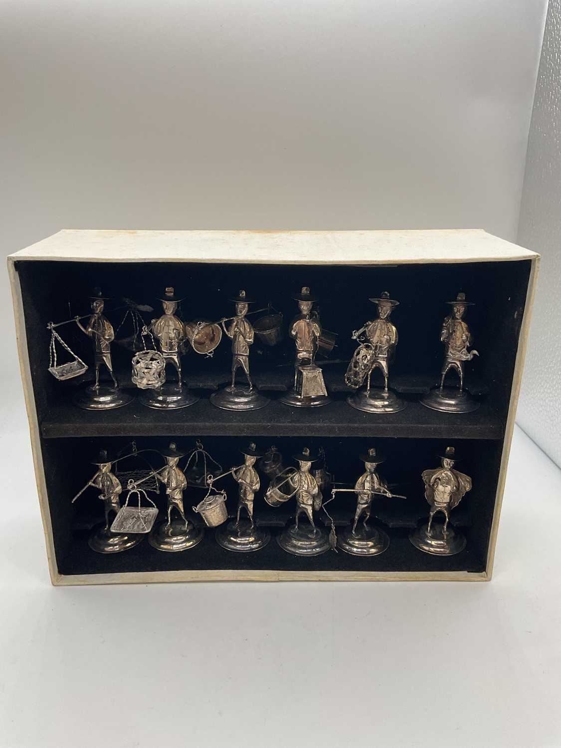 Lot 1074 - A set of twelve white metal miniature figures...