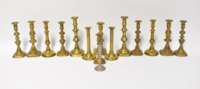 Lot 646 - A collection of fourteen brass candlesticks,...