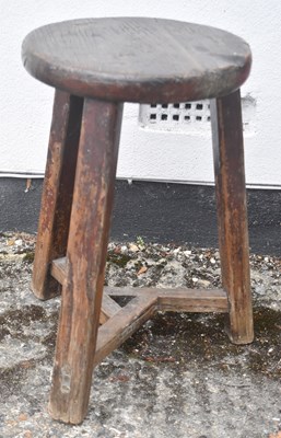 Lot 71 - A rustic oak milking stool with circular seat,...