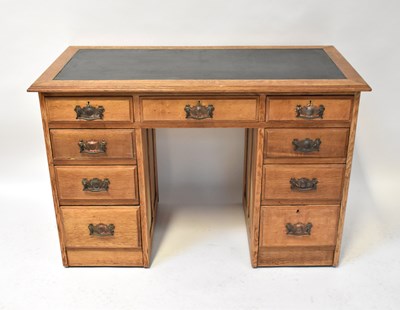 Lot 37 - An Edwardian oak nine-drawer kneehole desk,...