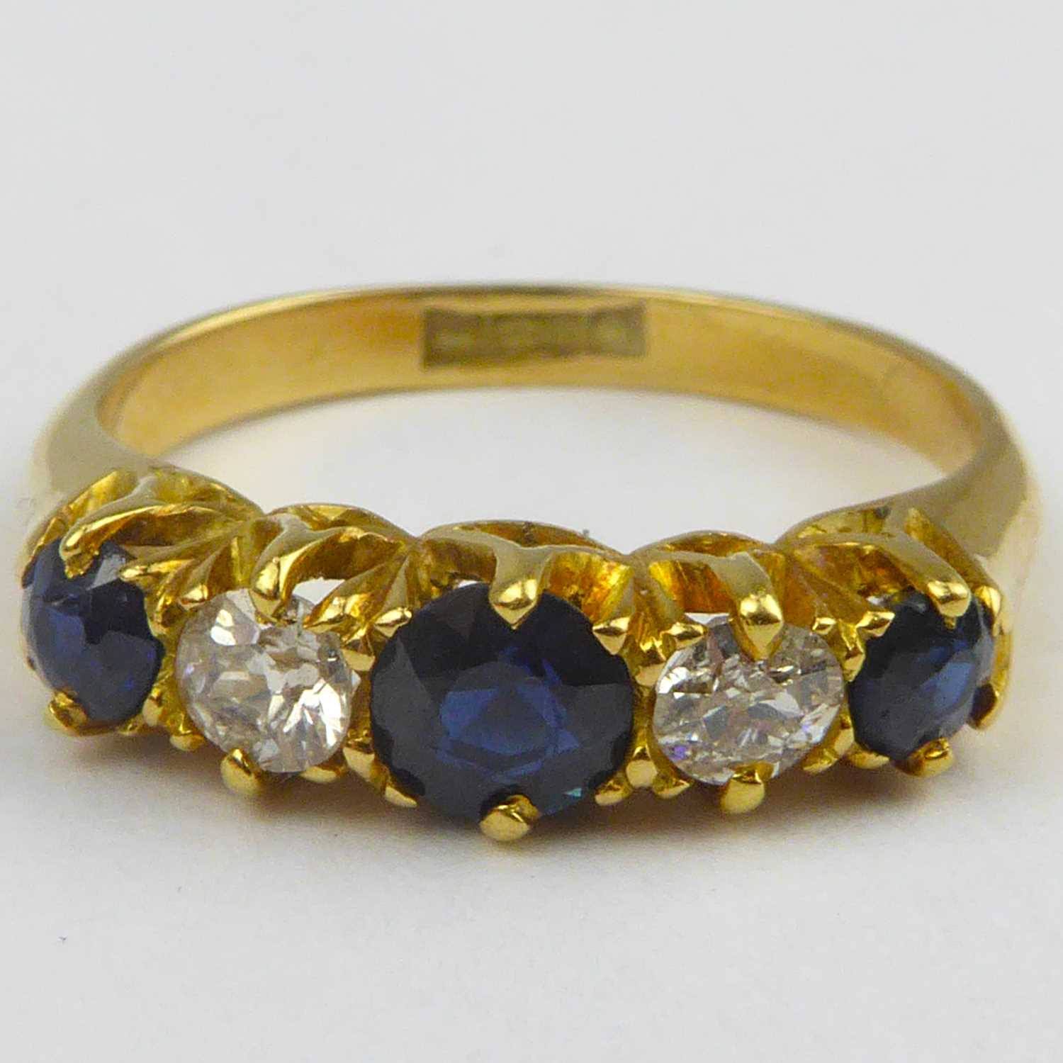 Lot 829 - An 18ct gold diamond and sapphire ring, the