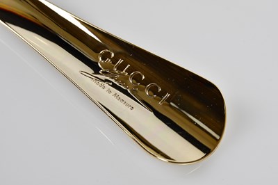 Lot 946 - GUCCI; a gold tone unused metal shoe horn...