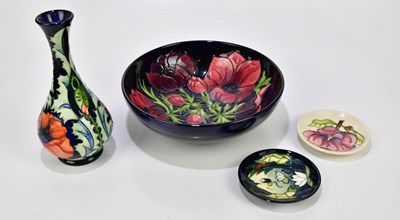 Lot 119 - MOORCROFT; four pieces including a vase of...