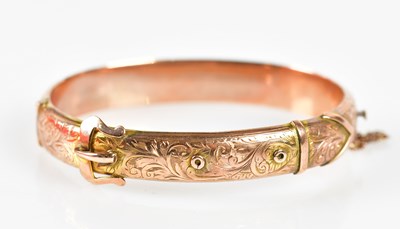 Lot 527 - A 9ct gold buckle snap bangle, approx weight 13g.