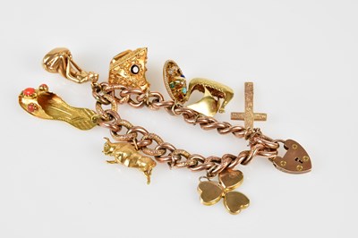 Lot 510 - A 9ct rose gold charm bracelet set with...