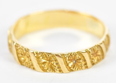 Lot 186 - A yellow metal engraved wedding band, marks...