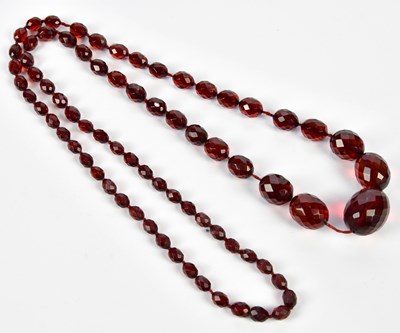 Lot 391 - A cherry amber facet cut graduated bead...