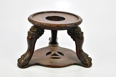 Lot 1121 - A Chinese carved rosewood vase stand on...