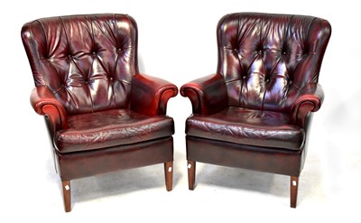 Lot 38 - A pair of modern oxblood leather button back armchairs