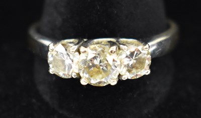 Lot 875 - An 18ct white gold three stone diamond ring,...