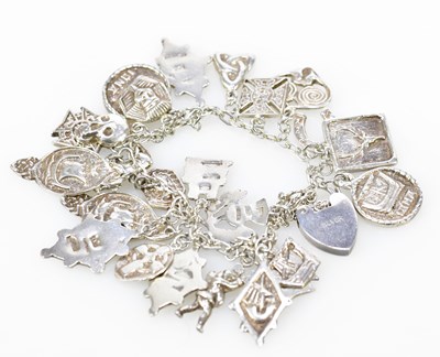 Lot 710 - A silver charm bracelet set with many Scottish...