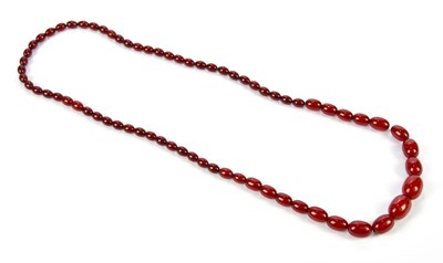 Lot 1035 - A cherry amber coloured beaded necklace,...