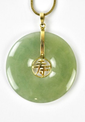 Lot 484 - A Chinese green hardstone pendant, possibly...