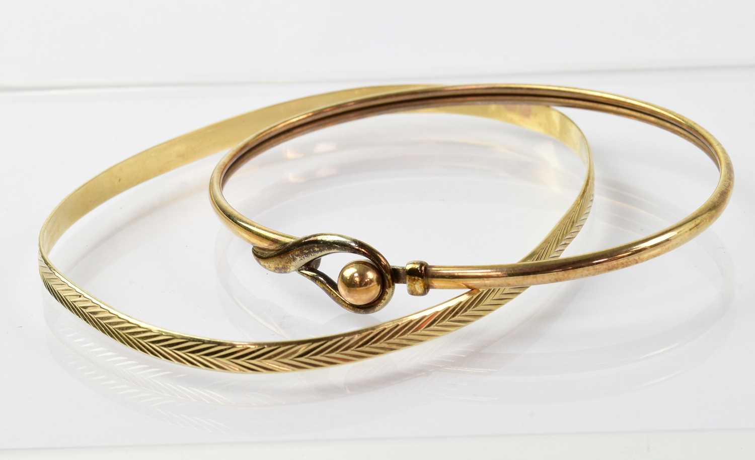 Lot 919 - Two 9ct gold bangles, one with...