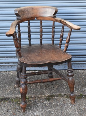 Lot 65 - An early 20th century oak captain's chair.