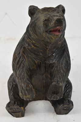 Lot 315 - A Black Forest carved model of a seated bear,...