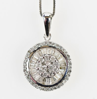 Lot 454 - A 9ct white gold diamond set circular pendant,...