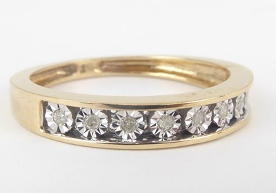 Lot 1033 - A 9ct gold half eternity ring with nine small channel set diamonds