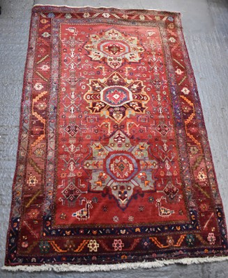 Lot 126 - A large Persian red ground floral decorated...