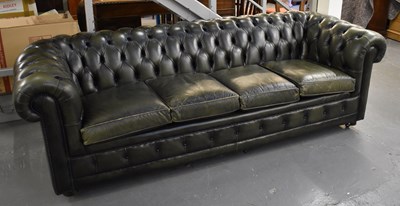 Lot 10 - A large green leather button upholstered four...