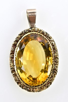 Lot 410 - A large oval mixed cut citrine pendant set in...