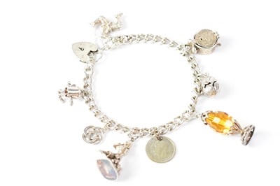 Lot 1074 - A silver charm bracelet with eight charms, to...