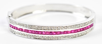 Lot 500 - An 18ct white gold diamond and ruby hinged...