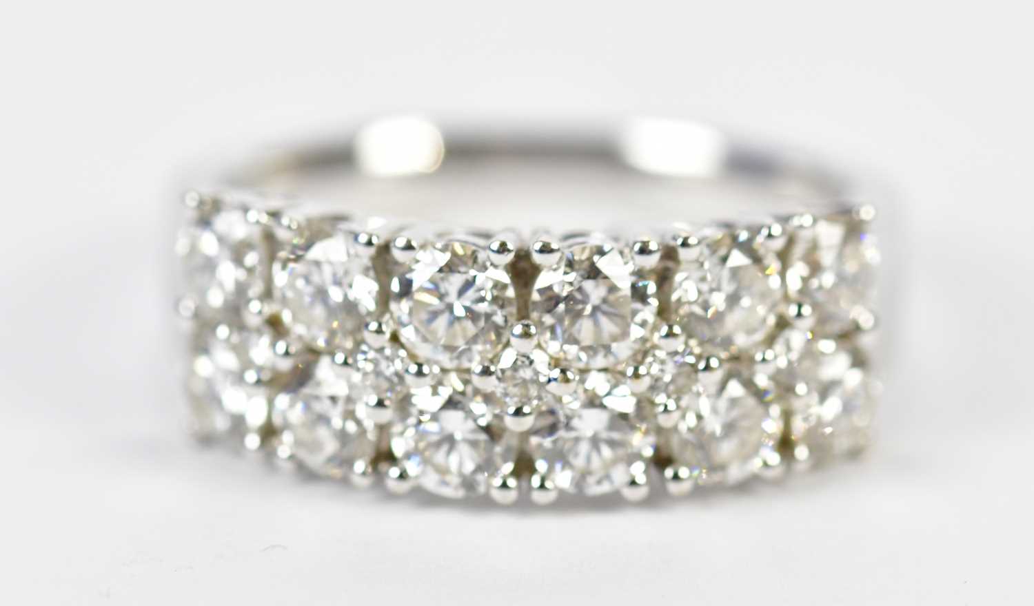 Lot 64 - An 18ct white gold diamond half eternity ring...