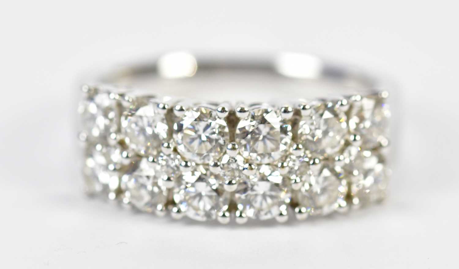 Lot 48 - An 18ct white gold diamond half eternity ring...