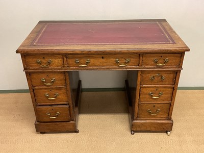 Lot 601 - An Edwardian oak nine drawer twin pedestal...