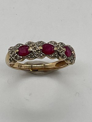 Lot 431 - A 9ct yellow gold three stone ruby and...