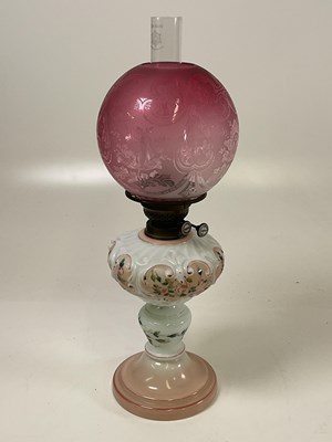 Lot 530 - An oil lamp with a cranberry glass shade,...