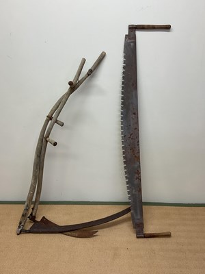 Lot 575 - A two man saw and two scythes.