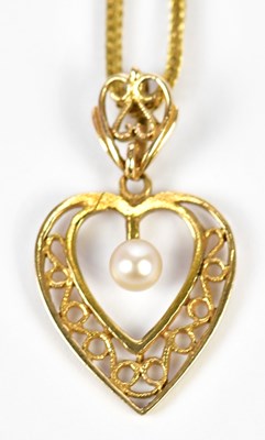 Lot 446 - A 9ct yellow gold chain suspending a heart...