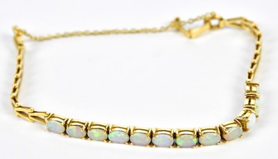 Lot 512 - An 18ct yellow gold and opal set bracelet with...