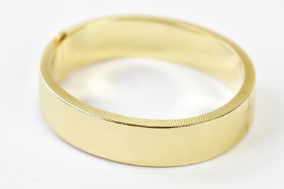 Lot 506 - A yellow metal oval hinged snap bangle with...