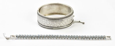 Lot 735 - A silver hinged snap bangle with band of...