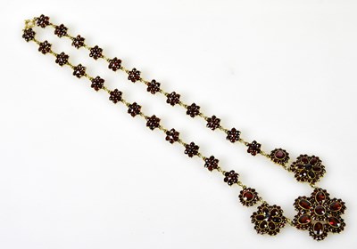 Lot 460 - A yellow metal and garnet necklace with three...