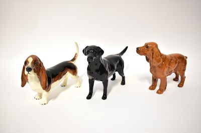 Lot 565 - BESWICK; three dogs comprising black Labrador...