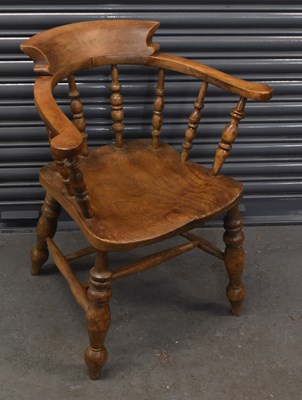 Lot 50 - An elm seated smoker's bow back elbow chair on...