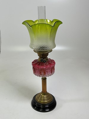 Lot 531 - An oil lamp with cranberry reservoir and green...