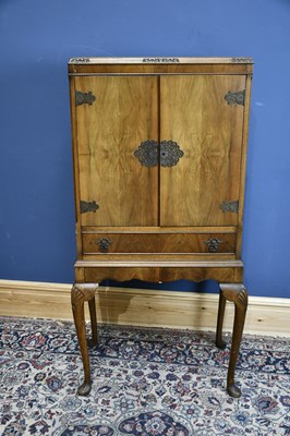 Lot 104 - A 20th century walnut cocktail cabinet, with...